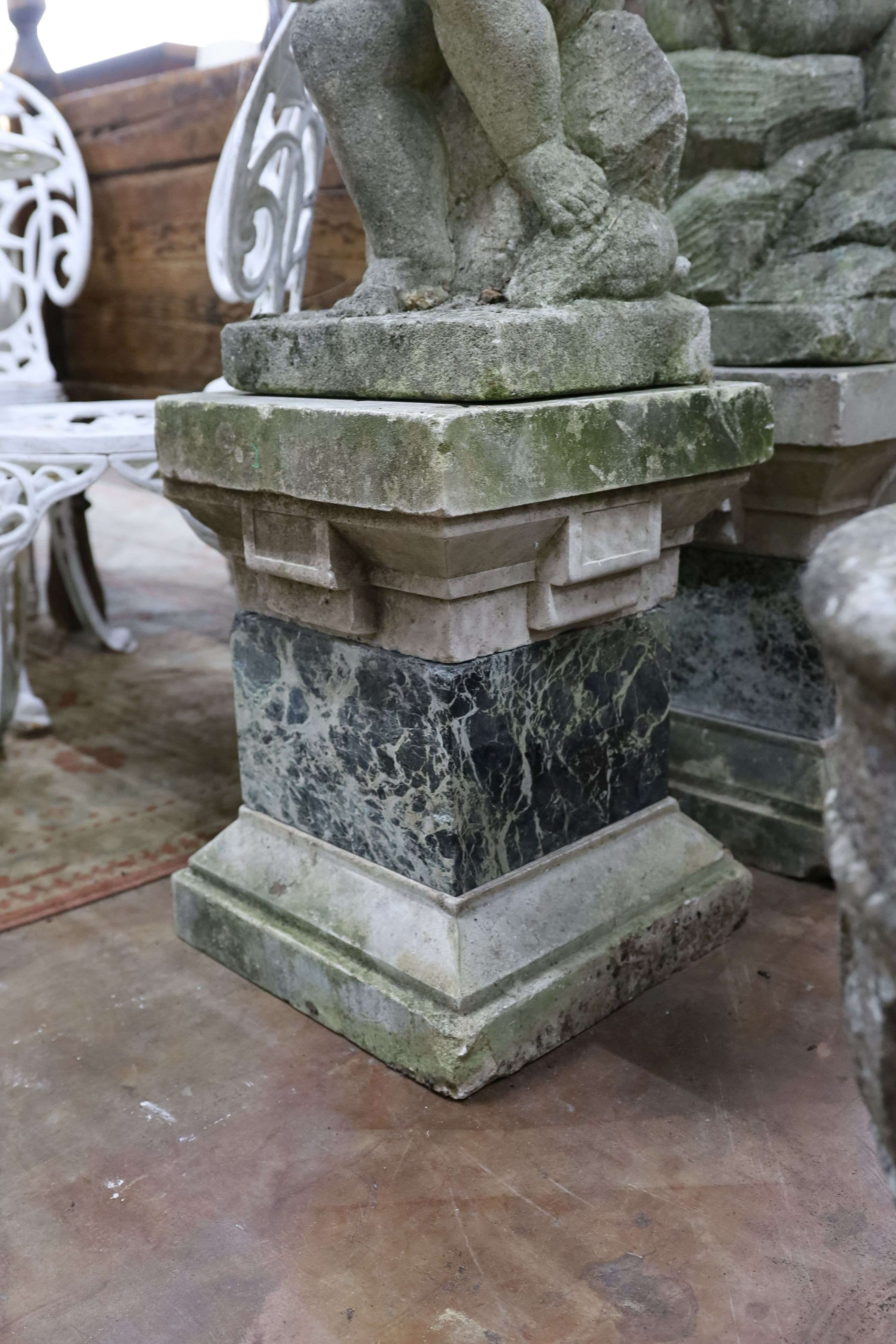 A pair of reconstituted stone cherub and dove garden ornaments on faux marble plinths, height 116cm
